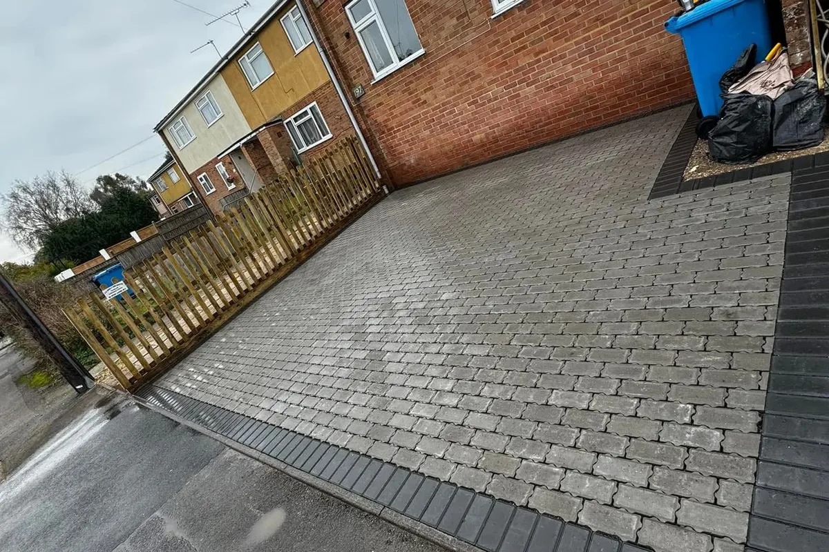 Block-paved driveway with a contrasting charcoal border sweeping up to a house