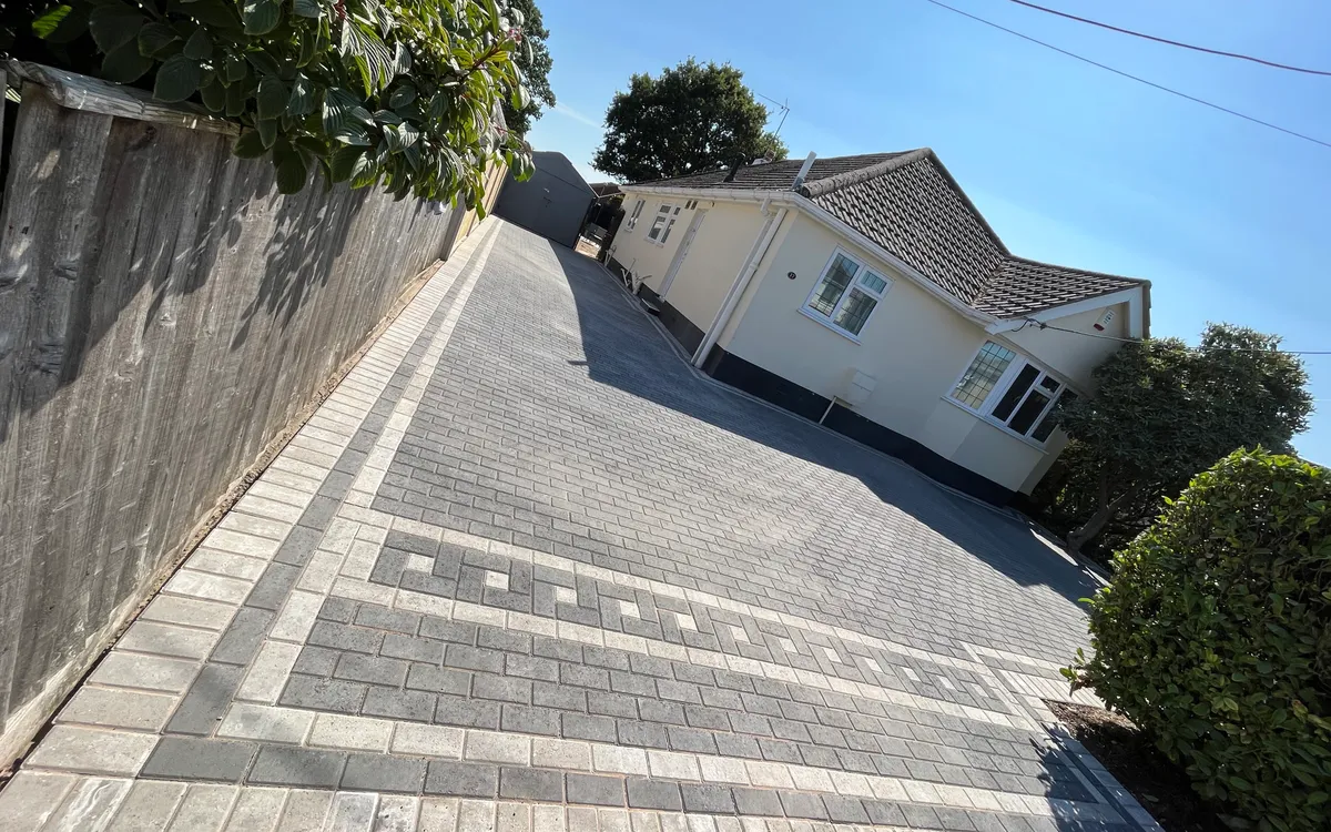 Block-paved driveway with a contrasting patterned border leading up to a bungalow