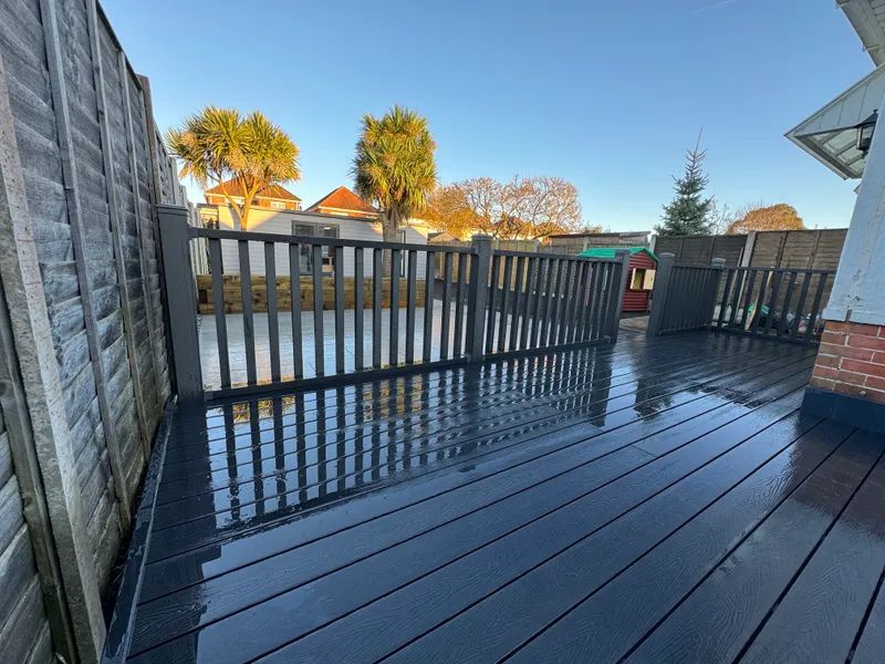 Dark composite decking with balustrade overlooking a porcelain patio