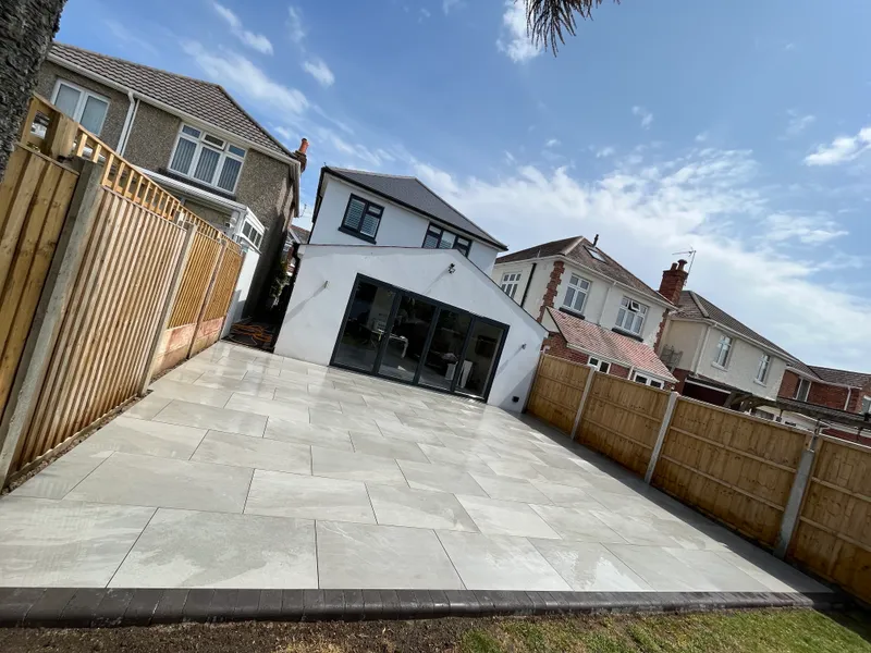 Porcelain patio with block edging enclosed by timber fencing